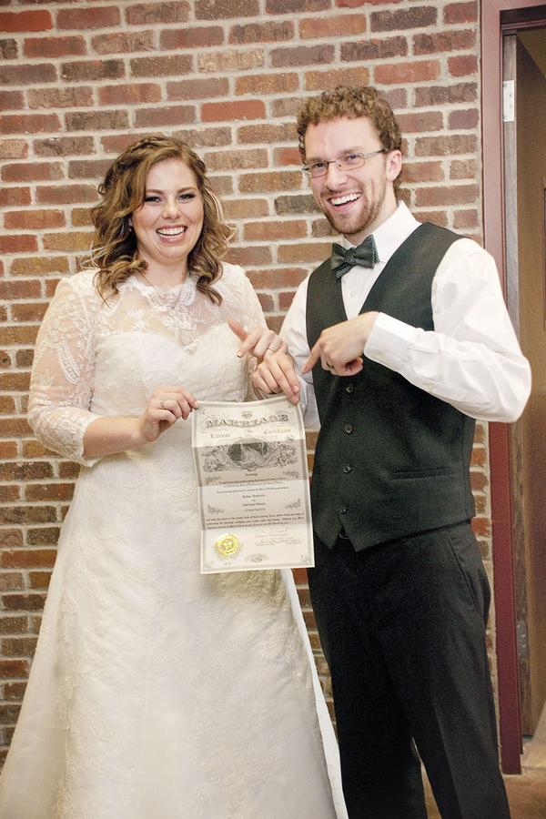 Gorgeous plus size bride and her dapper groom with their marriage license