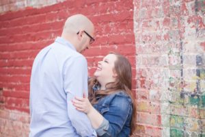 plus size bride to be and groom downtown by a brickwall