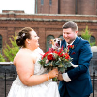 plus size bride and groom with dog wearing a flower collar